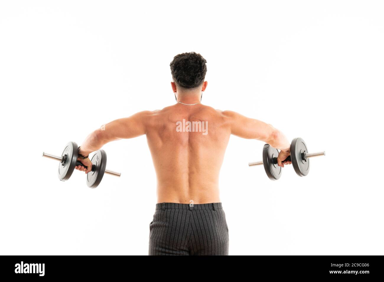 Uomo atletico che mostra corpo muscolare con manubri, vista posteriore, lunghezza intera, isolato su sfondo bianco Foto Stock