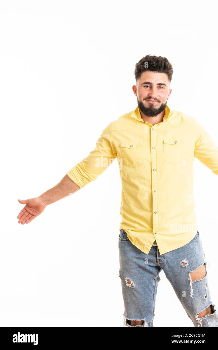 Ritratto di un ragazzo che indossa una camicia in denim, in piedi con le mani larghe mentre ride, isolato su sfondo bianco Foto Stock