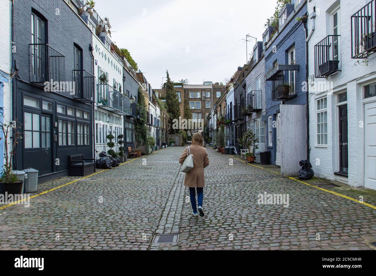 Ragazza che cammina in una strada residenziale a Londra, Regno Unito. Blocco di case londinesi. Architettura inglese. Eleganti edifici di appartamenti. Concetto immobiliare urb Foto Stock