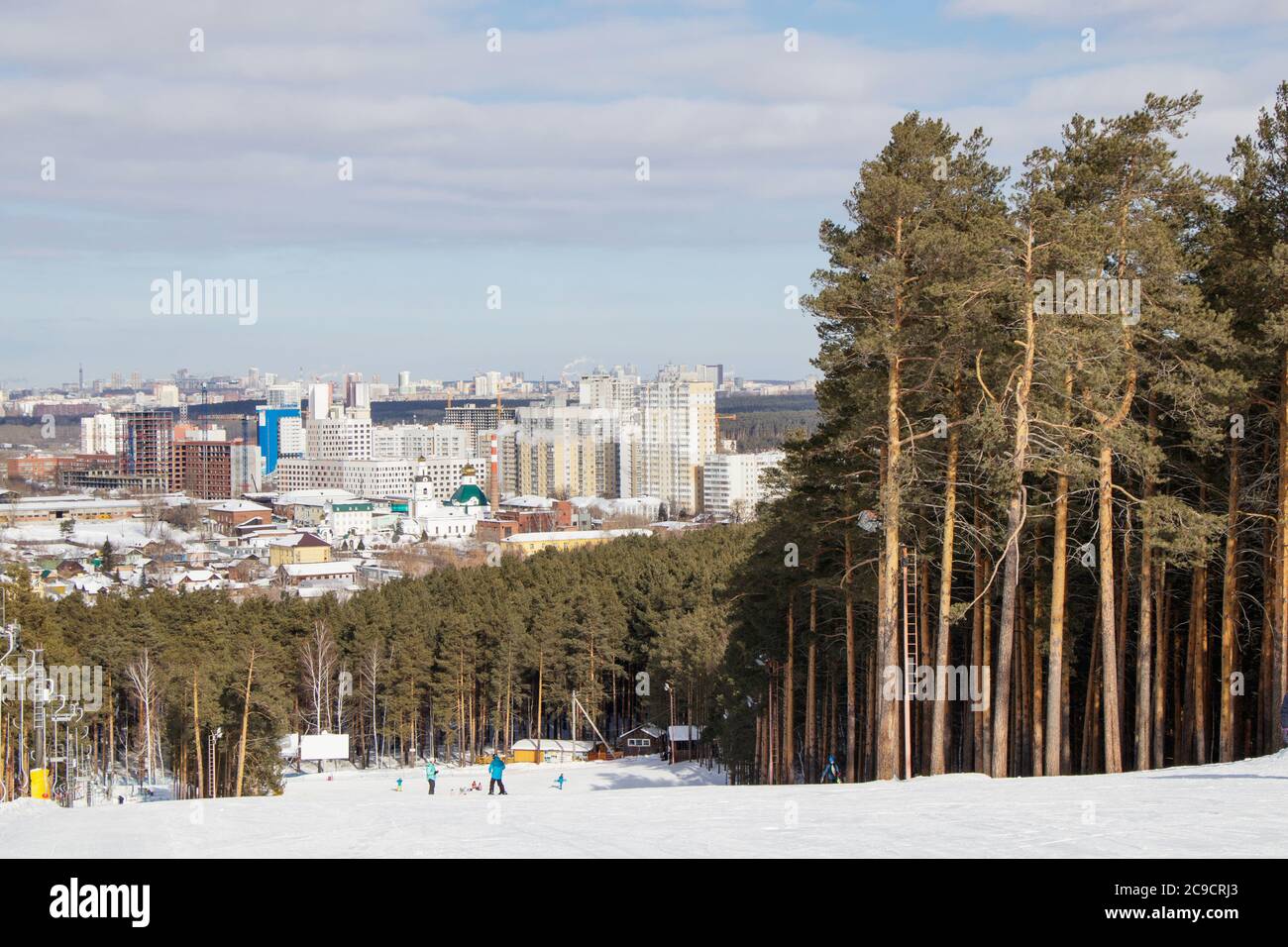 La pista di allenamento del complesso sportivo sul monte Uktus incorniciata da una pineta. Sullo sfondo un panorama della città di Ekaterinburg, Russia Foto Stock