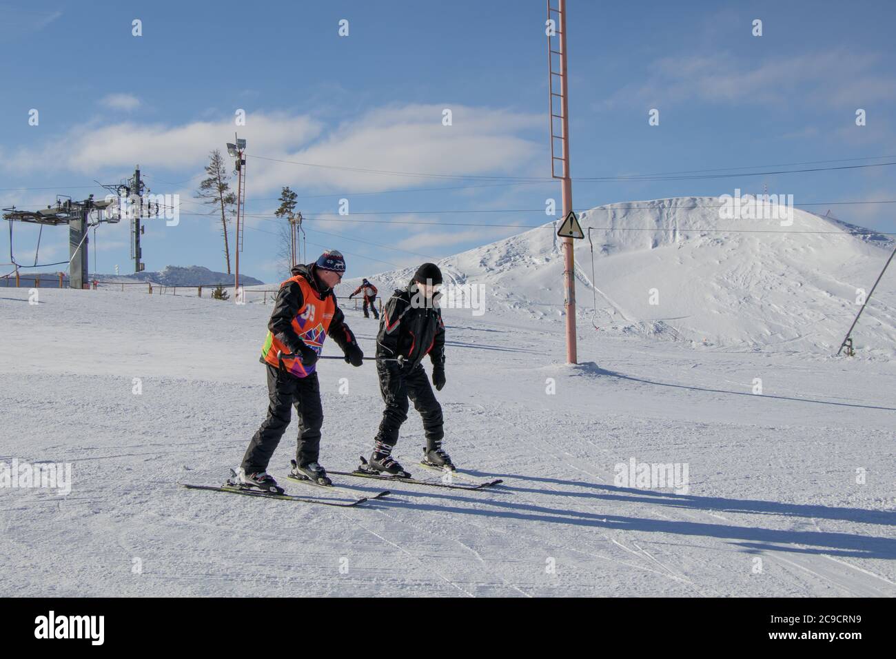 Ekaterinburg, Russia - 26 febbraio 2019. Pista di allenamento del complesso sportivo sul monte Uktus. Un allenatore anziano insegna a sciare un uomo. Foto Stock