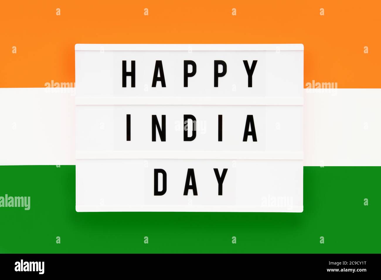 HAPPY INDIA GIORNO scritto in un lightbox su uno sfondo di colore della bandiera indiana. Data del giorno dell'indipendenza. Vista dall'alto. Foto Stock