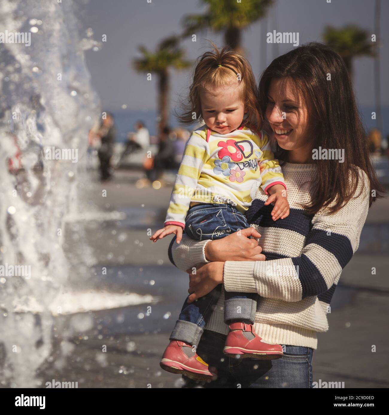 ODESSA, UCRAINA - 5 OTTOBRE 2014: Primo piano ritratto di bella bambina, bambina bionda in pullover colorato in mani madri in parco Foto Stock