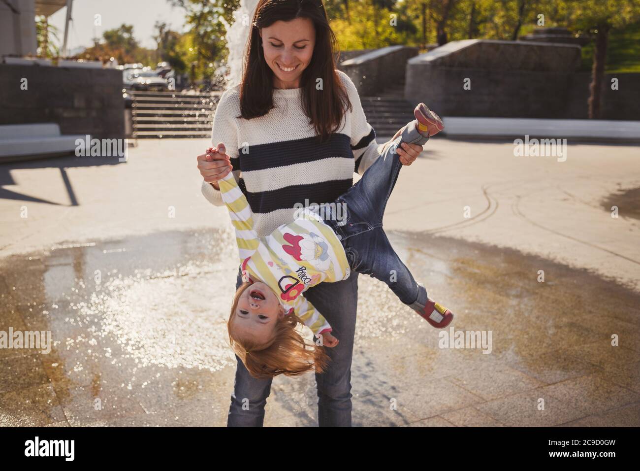 ODESSA, UCRAINA - 5 OTTOBRE 2014: Felice famiglia allegra amorevole, madre e piccola figlia in Disney Daisy Duck pullover giocare nel parco accanto a. Foto Stock