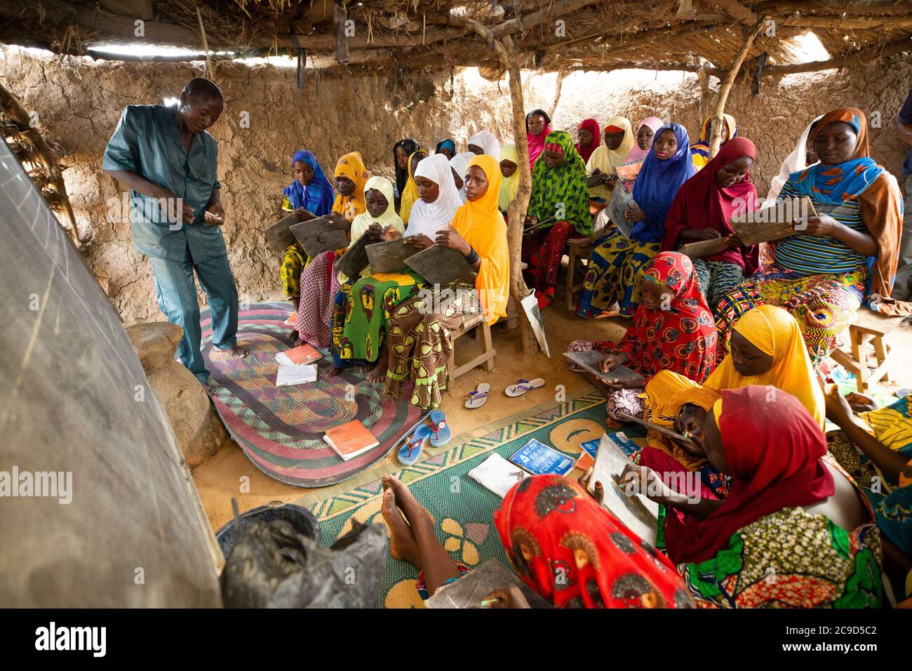 Le donne e le ragazze che non hanno precedentemente ricevuto un'istruzione partecipano ad una classe di alfabetizzazione funzionale guidata dall'istruttore Garba Ali (48, L) nella regione di Tahoua, Niger. Progetto Alliance 12/12 - Niger, Africa occidentale. 18 settembre 2018. Foto di Jake Lyell per il Luterano World Relief. Foto Stock