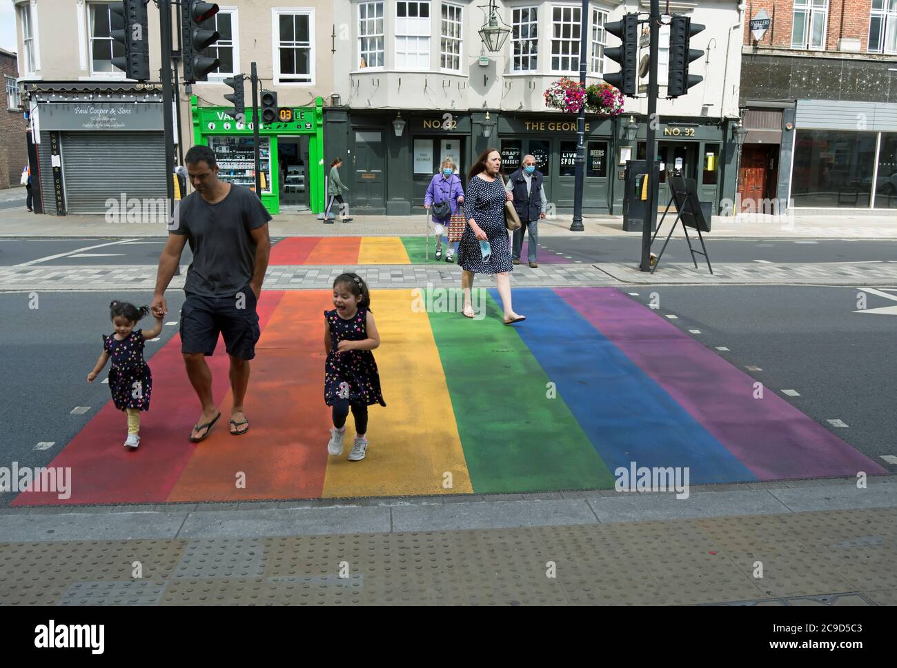 i bambini e gli adulti utilizzano un attraversamento della strada arcobaleno dipinto, che mostra il sostegno del consiglio alla comunità lbgtq+ di twickenham, middlesex, inghilterra, Foto Stock