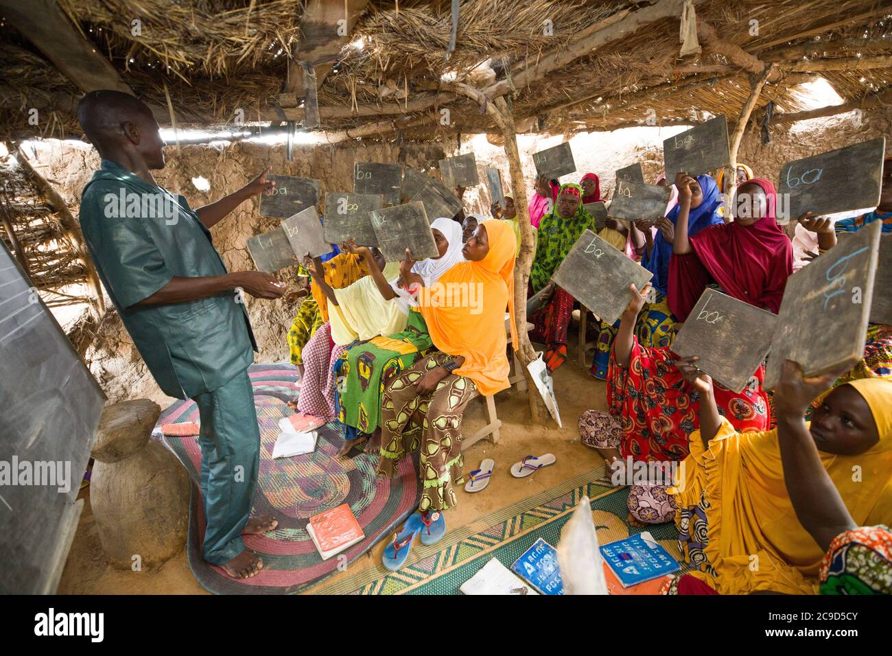 Le donne e le ragazze che non hanno precedentemente ricevuto un'istruzione partecipano ad una classe di alfabetizzazione funzionale guidata dall'istruttore Garba Ali (48, L) nella regione di Tahoua, Niger. Progetto Alliance 12/12 - Niger, Africa occidentale. 18 settembre 2018. Foto di Jake Lyell per il Luterano World Relief. Foto Stock