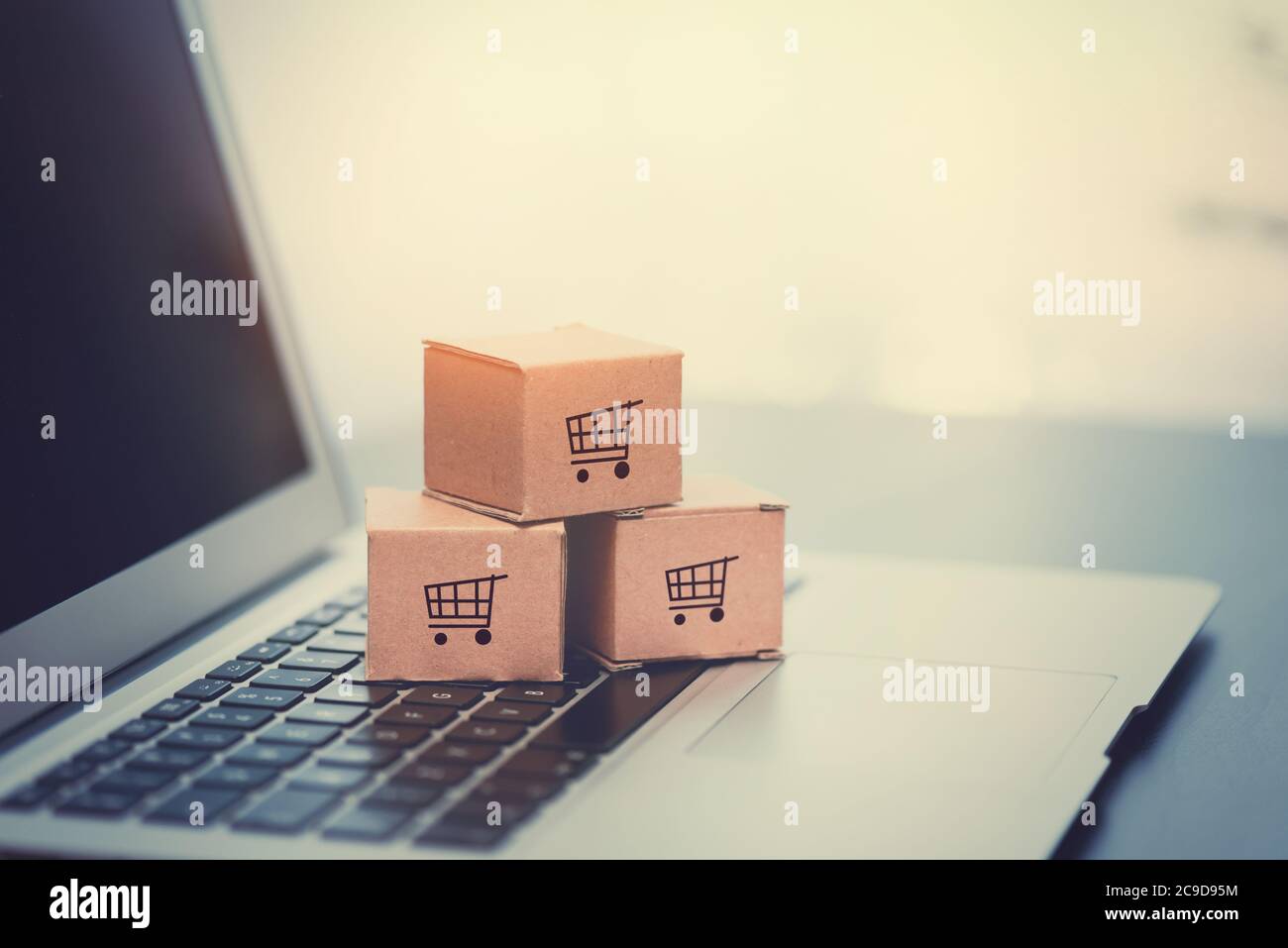 Scatole sulla tastiera del computer portatile. E-commerce, concetto di shopping online. Foto Stock