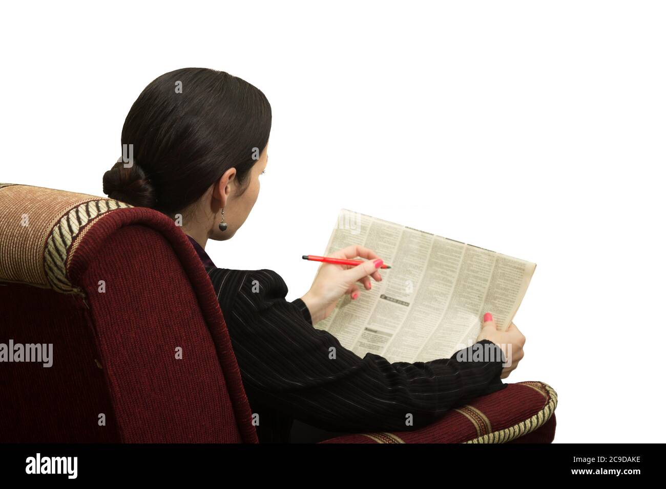 Giovane donna in sedia che legge un giornale con un annuncio - in cerca di lavoro Foto Stock