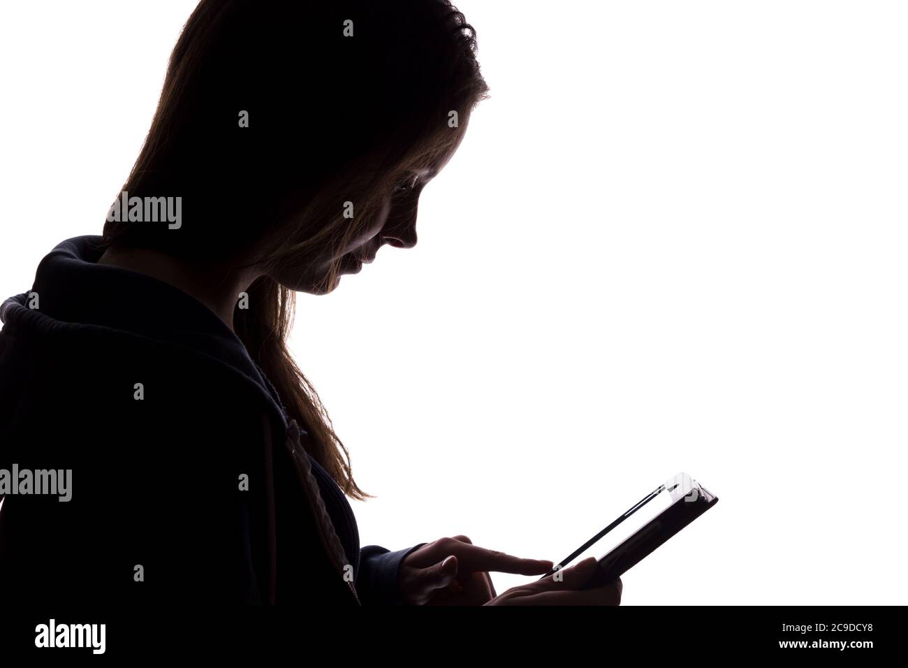 Silhouette di una ragazza nel cappuccio con un tablet, un simbolo di anonimato in Internet - isolare Foto Stock