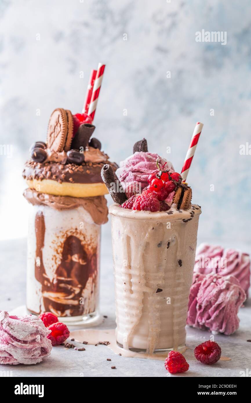Frullato al cioccolato con frittella e ciambelle. Folle tendenza alimentare freakshake. Spazio di copia Foto Stock