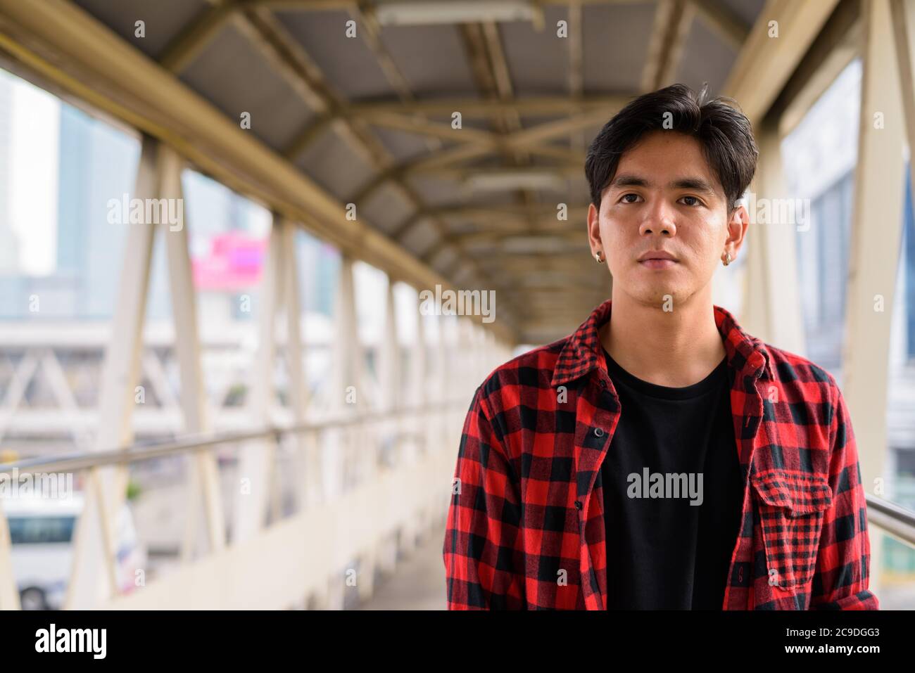 Giovane bello hipster asiatico a passerella in città Foto Stock