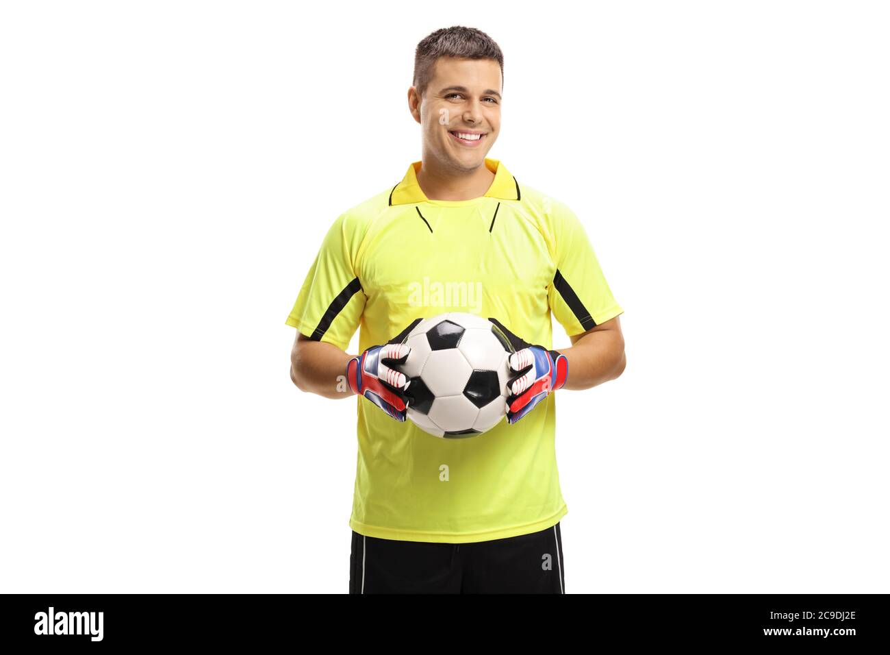 Portiere di calcio che tiene una palla e sorridente isolato su sfondo bianco Foto Stock