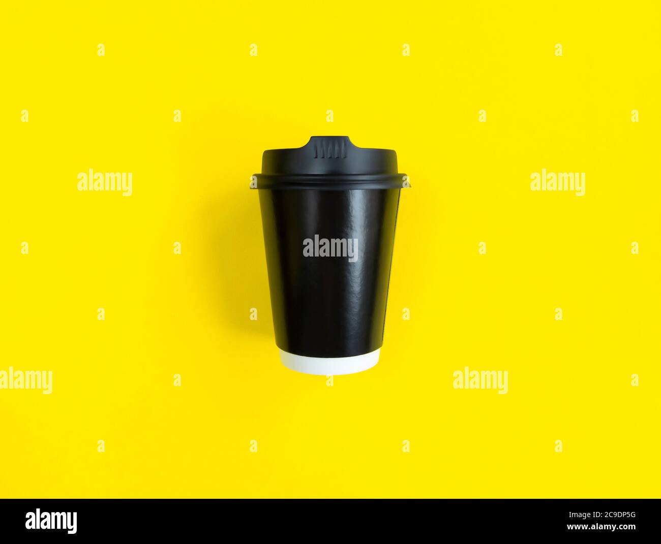 Tazza di caffè di carta nera per passare sullo sfondo giallo. Stile di posa piatto. Concetto minimo. Foto di scorta. Foto Stock