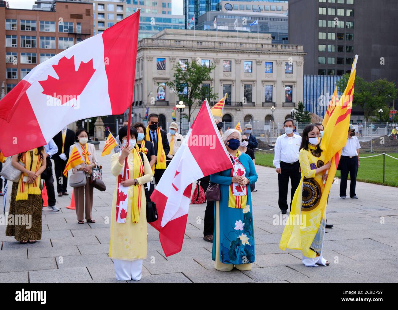 I Canadiani vietnamiti si riuniscono ad Ottawa, in onore del viaggio per la Giornata della libertà. Innalzamento della bandiera vietnamita della libertà, partecipante che indossa sciarpe di libertà Foto Stock