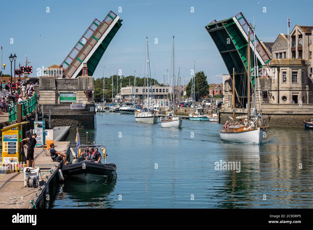 Tre yacht che navigano sotto il ponte di Weymouth con il ponte completamente aperto a Weymouth Harbour, Dorset, Regno Unito, il 22 luglio 2020 Foto Stock
