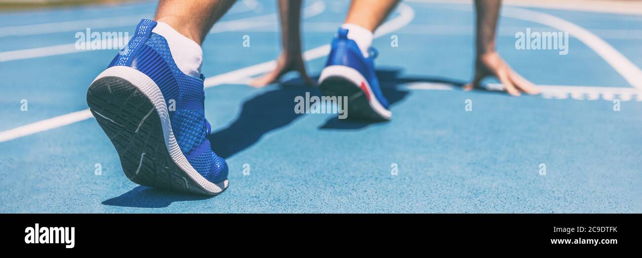 Sprinter in attesa di inizio gara su piste da corsa allo stadio all'aperto. Atleta sportivo e sportivo su pista blu con scarpe da running Foto Stock