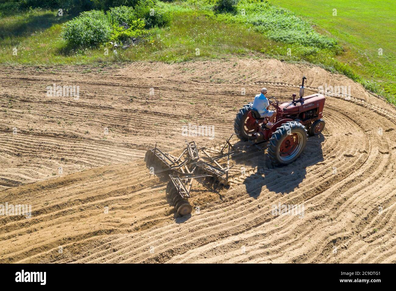 Otsego, Michigan - UN agricoltore di 90 anni guida un trattore Farmall Model M, sbarcando un campo in una piccola azienda agricola nel Michigan occidentale. Trebbiatrice internazionale Foto Stock