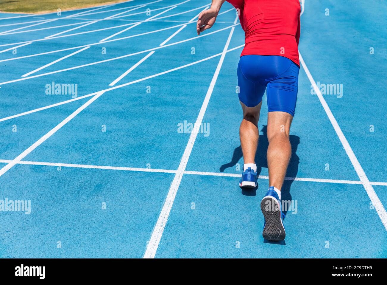 Atleta di runner che inizia a correre all'inizio della pista su piste da corsa blu all'aperto e allo stadio dei fiel. Stampante. Uomo sportivo e fitness Foto Stock