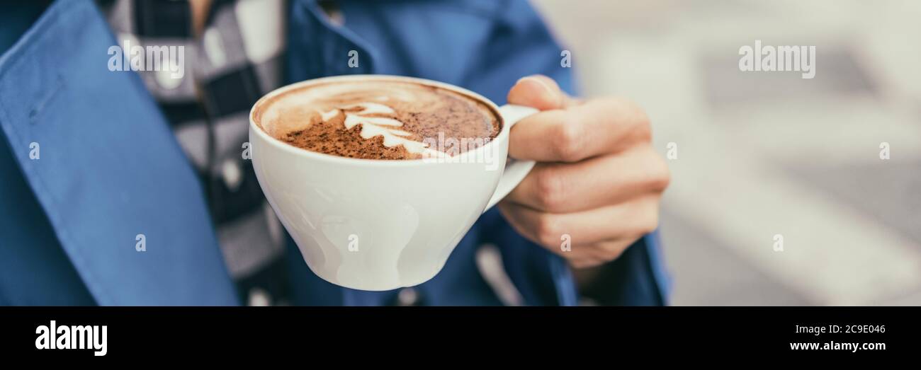Tazza di caffè cappuccino donna che beve latte presso il caffè all'aperto. Caffetteria City Lifestyle banner panorama closeup di latte art Cup tenuta a mano. Foto Stock