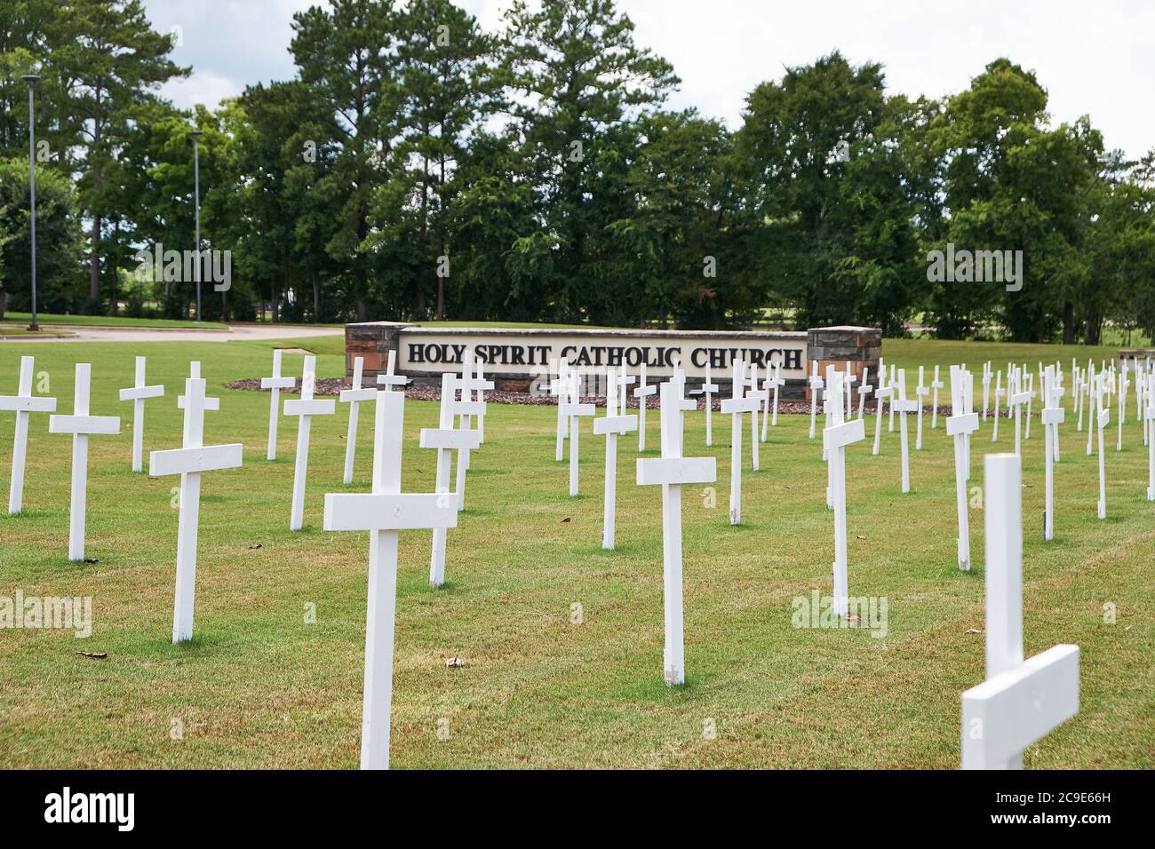 Mostra anti-aborto di fronte a una chiesa cattolica con numerose croci nel terreno a Montgomery Alabama, Stati Uniti. Foto Stock