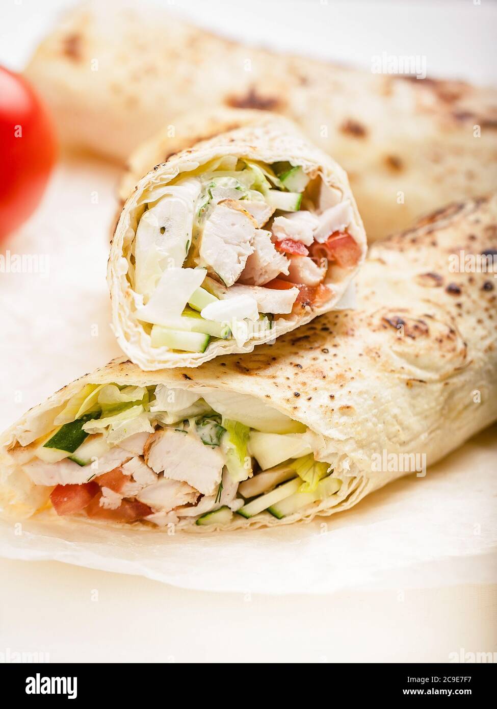 Shawarma tradizionale con pollo. Rotolare in una tortilla di grano con verdure, insalata e pollo. Cibo turco. Shot verticale Foto Stock