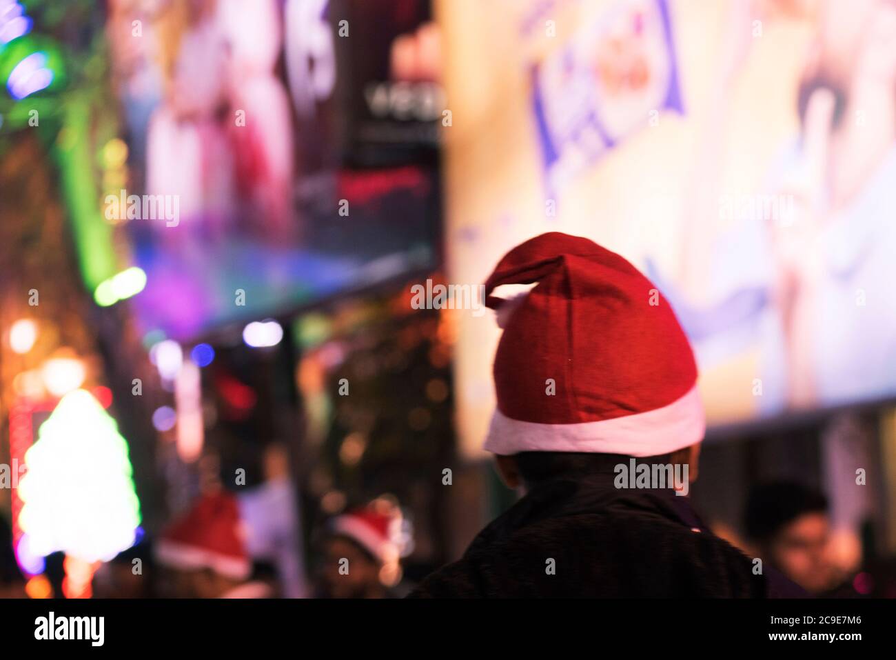 Giovane bella ragazza sta guardando la folla di Natale indossare cappello di Natale. Foto Stock