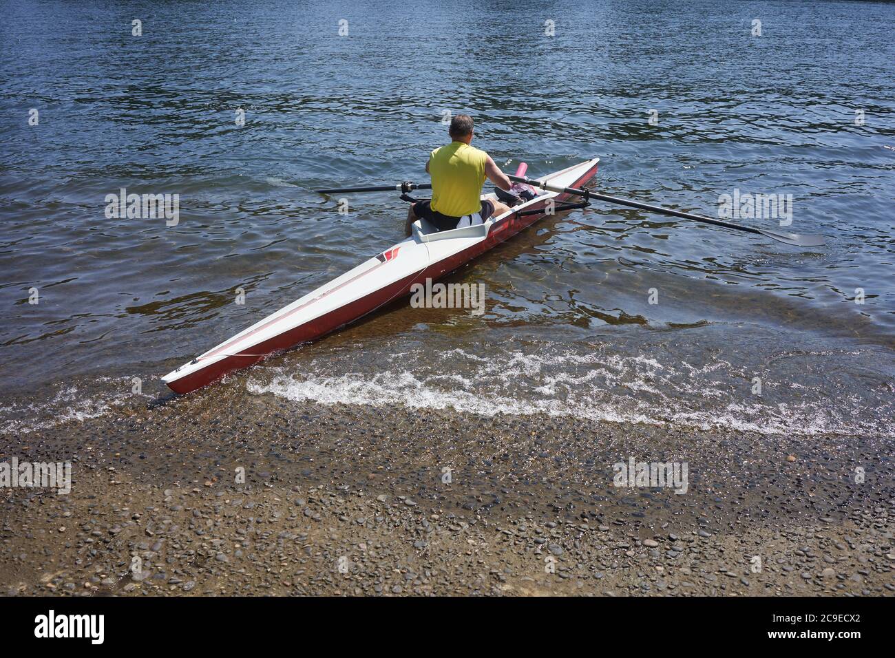 Un uomo lancia il suo kayak su una rampa di accesso sul fiume Willamette nel lago Oswego, Oregon. Foto Stock
