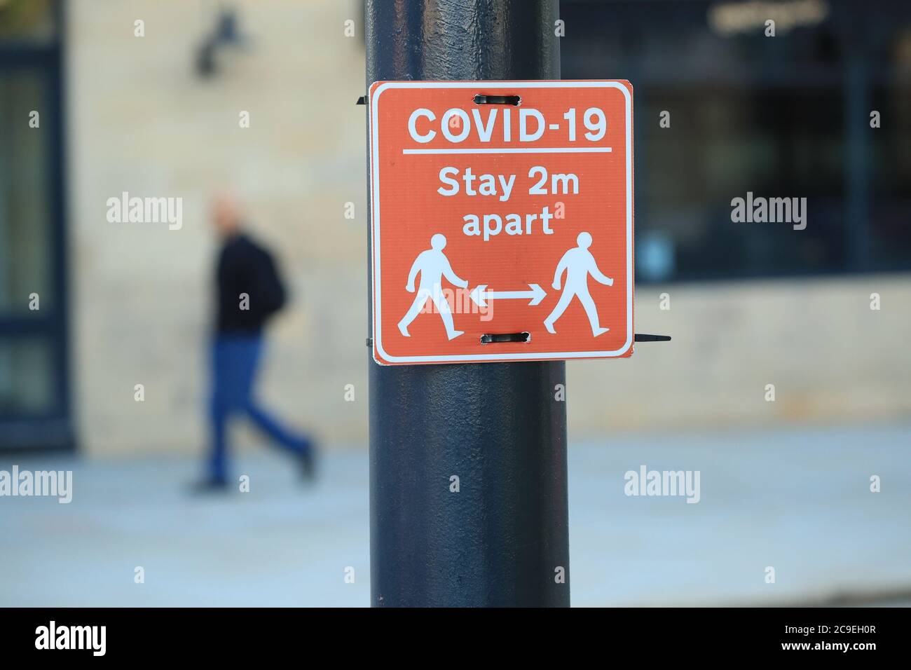 Un cartello che consiglia di stare a due metri di distanza su un lampione nel centro di Bradford, nello Yorkshire occidentale, una delle aree in cui sono state attuate nuove misure per prevenire la diffusione del coronavirus. Sono state introdotte norme più severe per le persone nella Greater Manchester, in alcune zone del Lancashire orientale e nello Yorkshire occidentale, che vietano ai membri di famiglie diverse di incontrarsi in luoghi chiusi. Foto Stock