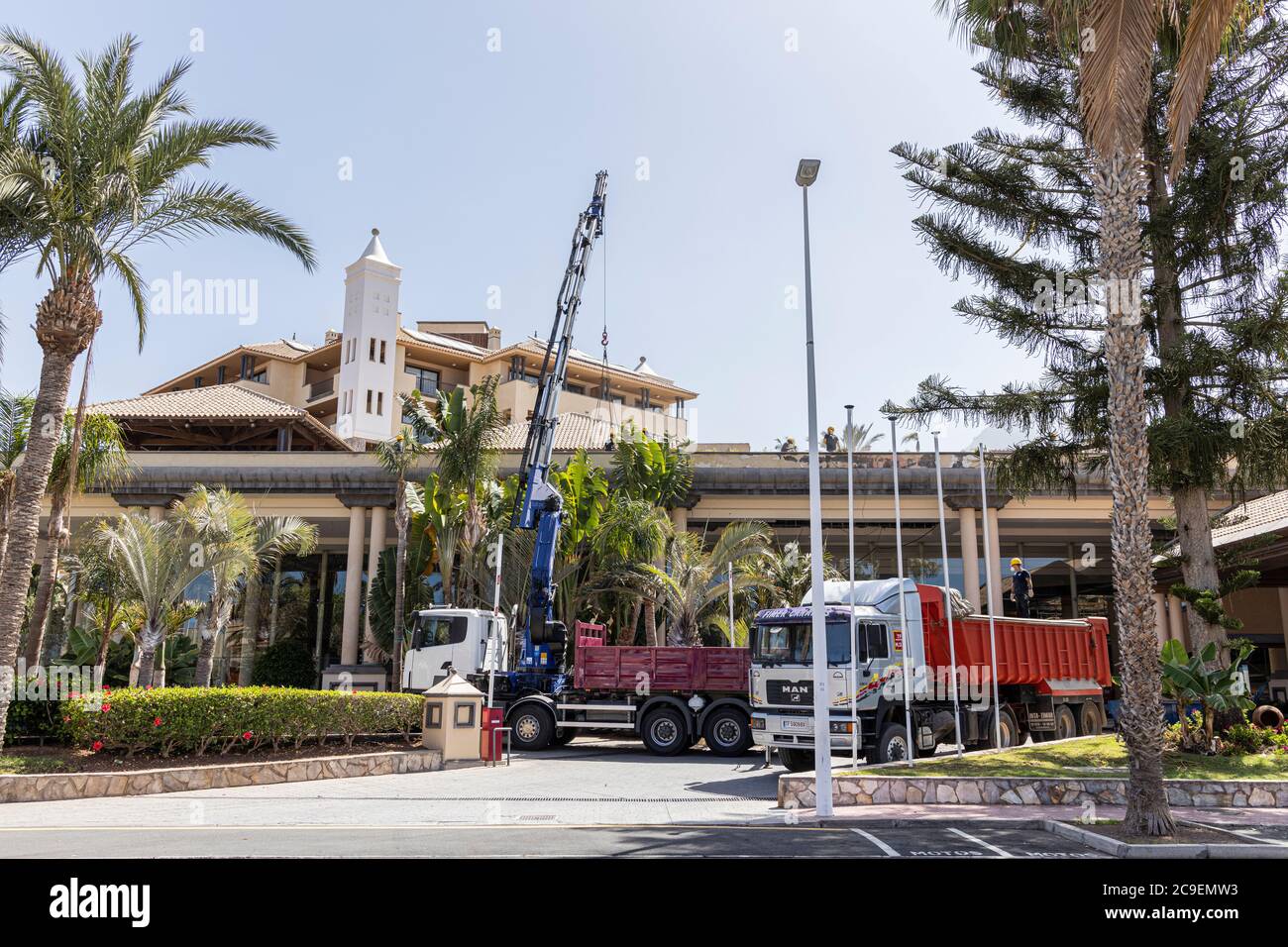 Lavori di ristrutturazione al GF Costa Adeje Gran Hotel in seguito alla chiusura del Covid 19, camion e gru fuori dall'hotel Foto Stock