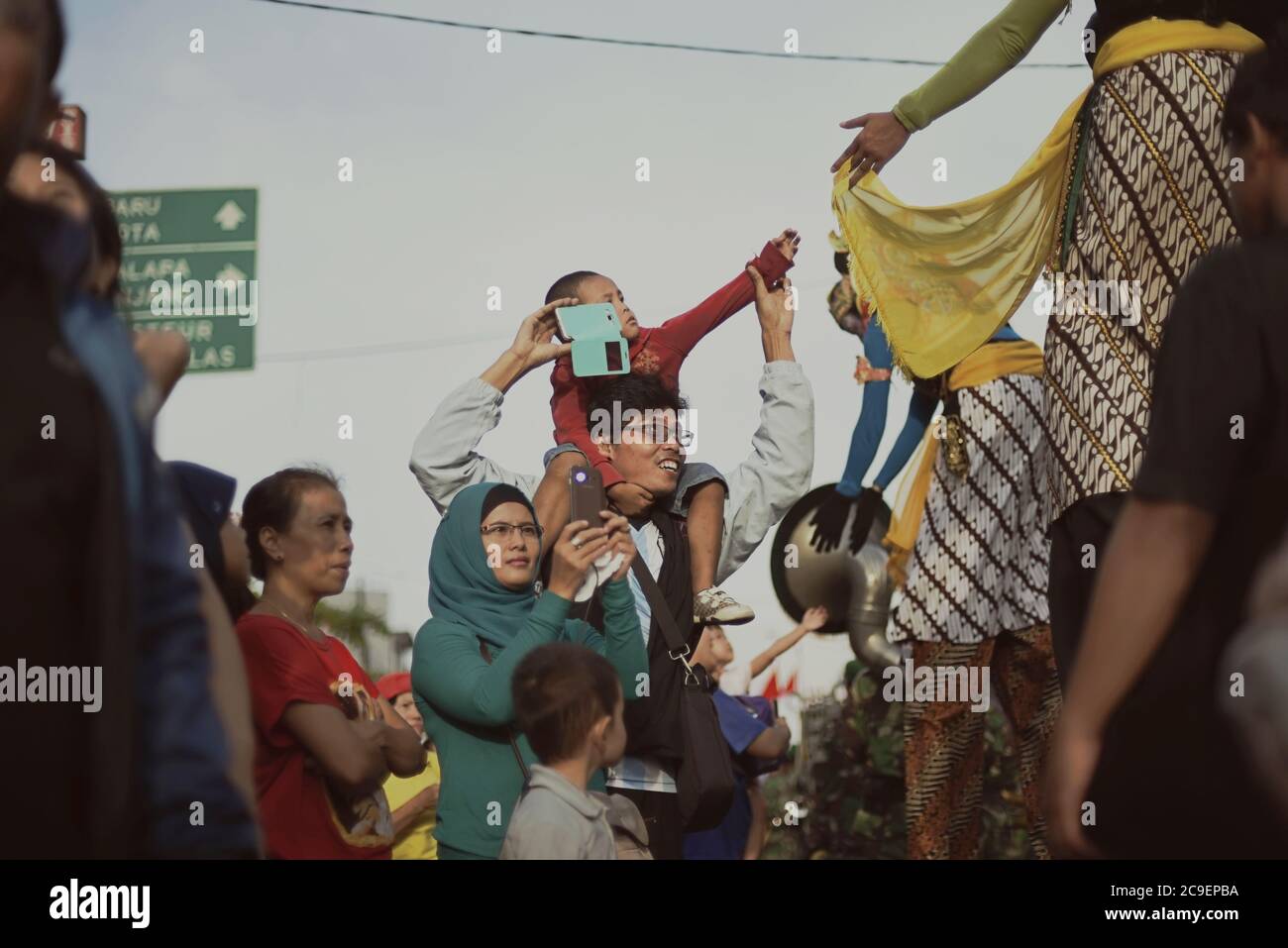 Gli spettatori salutano gli escursionisti che indossano costumi di carattere wayang durante la sfilata culturale del Bandung Lantern Festival 2015 a Bandung, Indonesia. Foto Stock