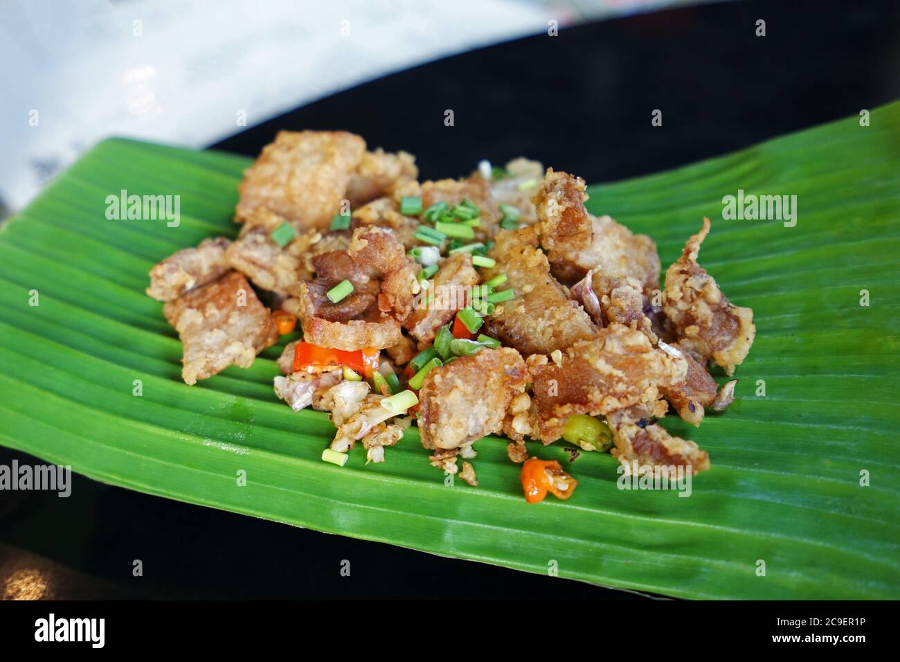 Primo piano peperoncino e aglio serviti con pancia di maiale croccante e fritta Foto Stock