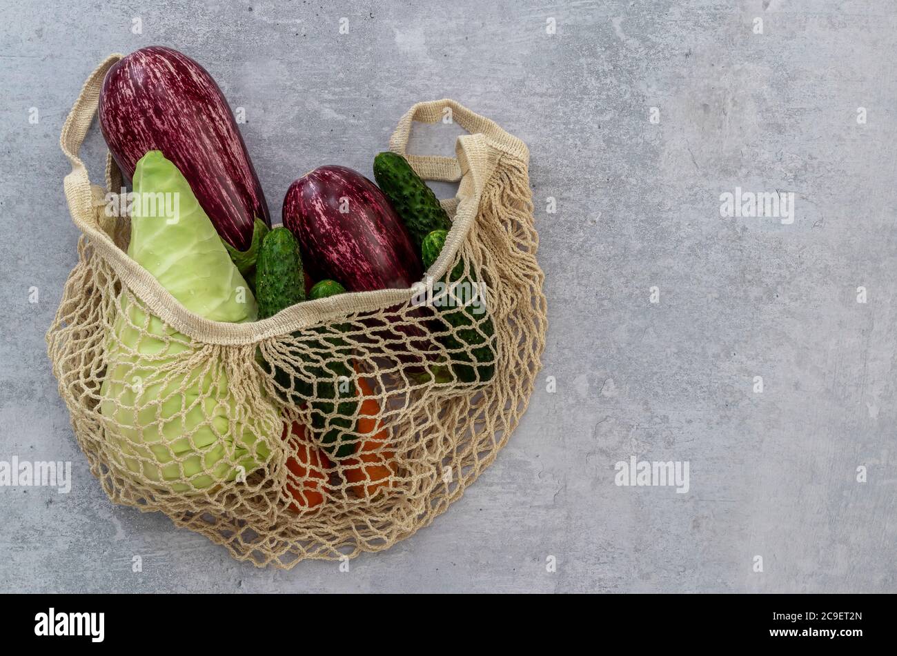 Assortite le verdure in una borsa a corda di tessuto su uno sfondo chiaro. Nessun concetto di shopping in plastica. Foto Stock