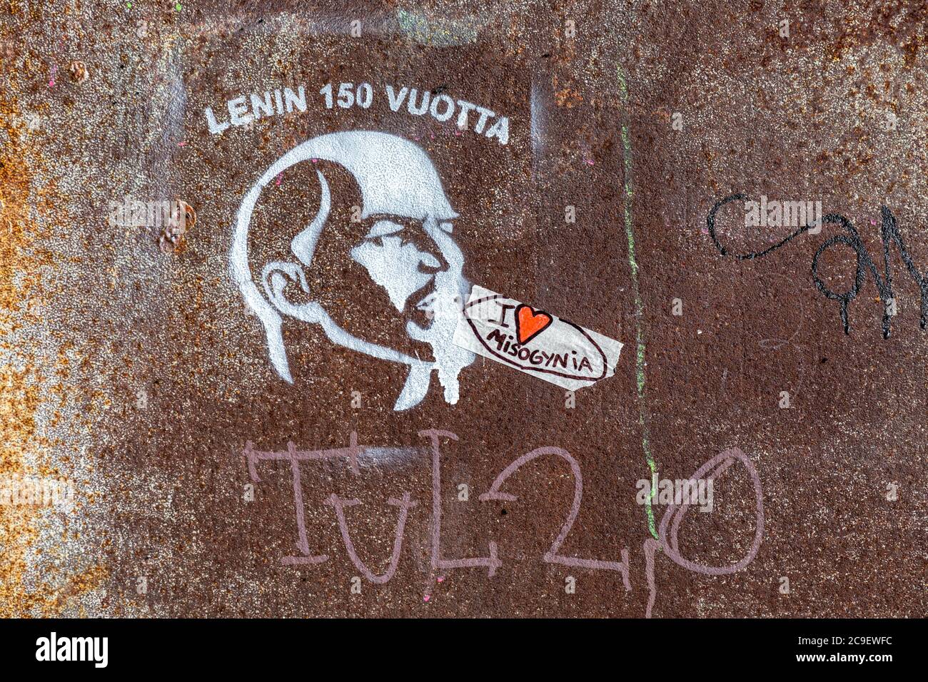 Amo la misoginia. Adesivo fatto a mano accanto a graffiti con stencil Lenin su una porta in metallo arrugginito a Helsinki, Finlandia. Foto Stock