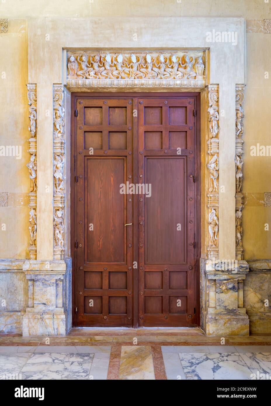 Chiuso elegante porta in legno installata in un arco ornamentale fuori del vecchio edificio in marmo Foto Stock