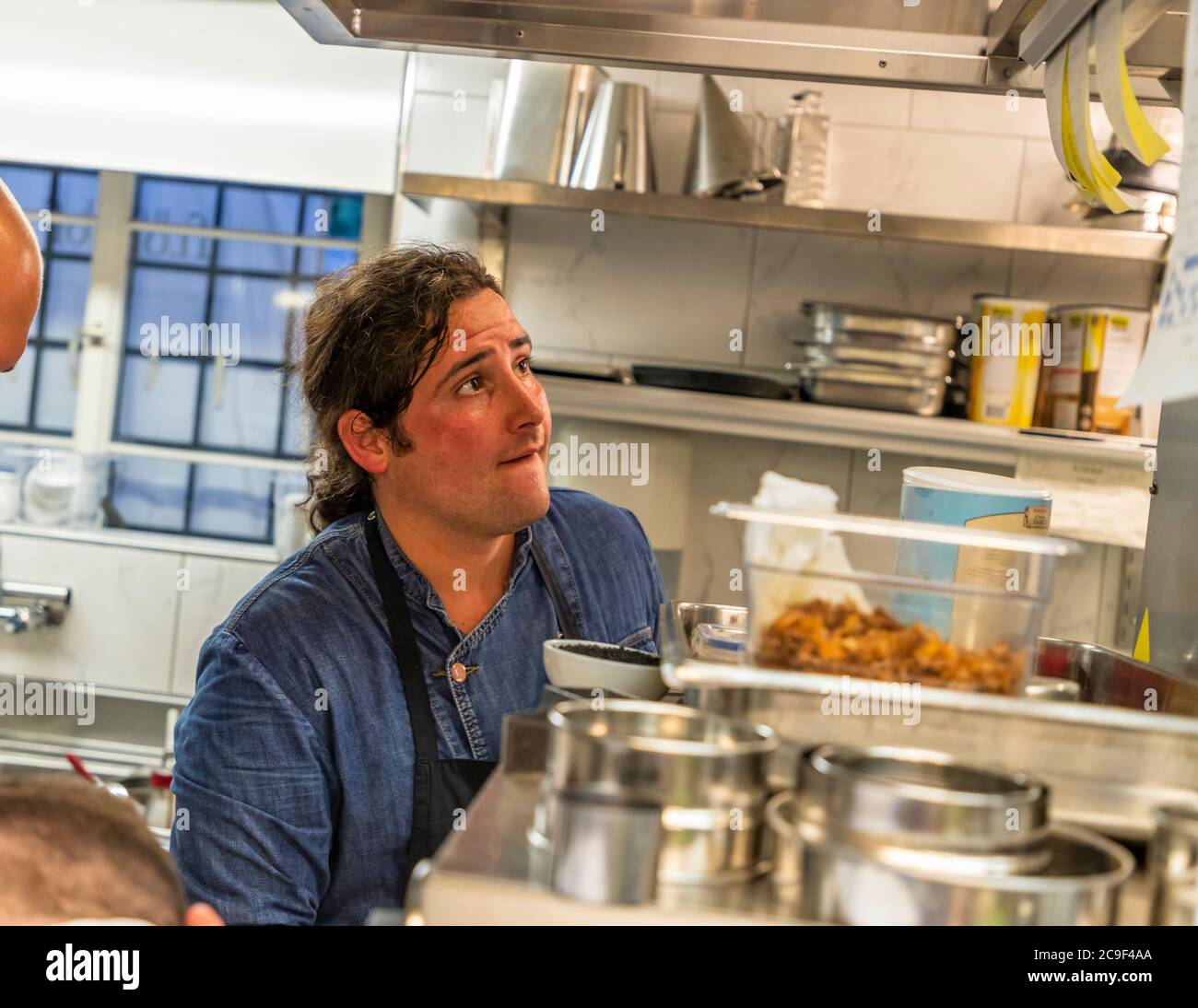 Lo chef Marc Homberger guarda in alto nella cucina del boutique Hotel Florhof a Zurigo, Svizzera, mentre prepara un piatto. Costruito nel 1763 per la famiglia di tessitori di seta Oeri-Lavater, l'edificio divenne la Pension Florhof nel 1907. Le attività alberghiere sono terminate nel 2022. È stata annunciata una riapertura come "Villa Florhof". Foto Stock