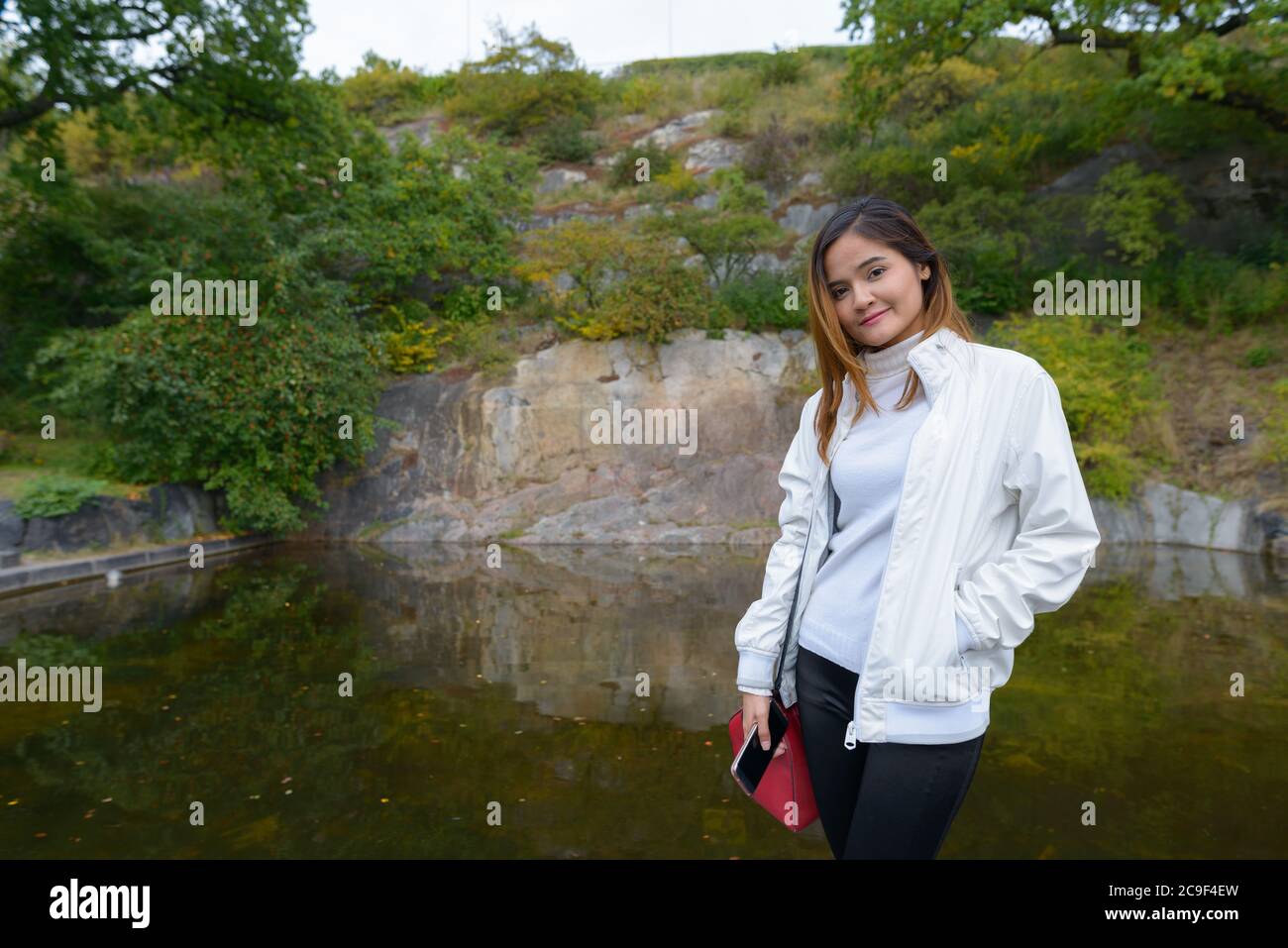 Giovane bella donna turistica asiatica contro la vista del lago in natura Foto Stock