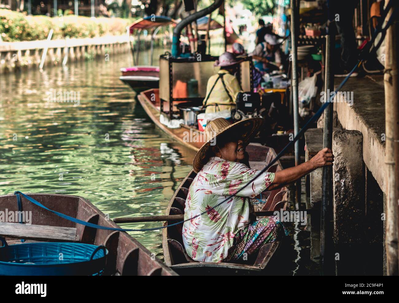 Venditore di donne thailandesi che vende frutta e verdura al mercato galleggiante di Taling Chan vicino a Bangkok, Thailandia. Foto Stock