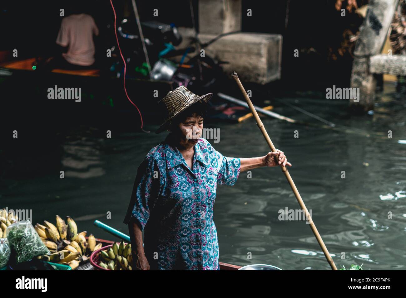 Venditore di donne thailandesi che vende frutta e verdura al mercato galleggiante di Taling Chan vicino a Bangkok, Thailandia. Foto Stock