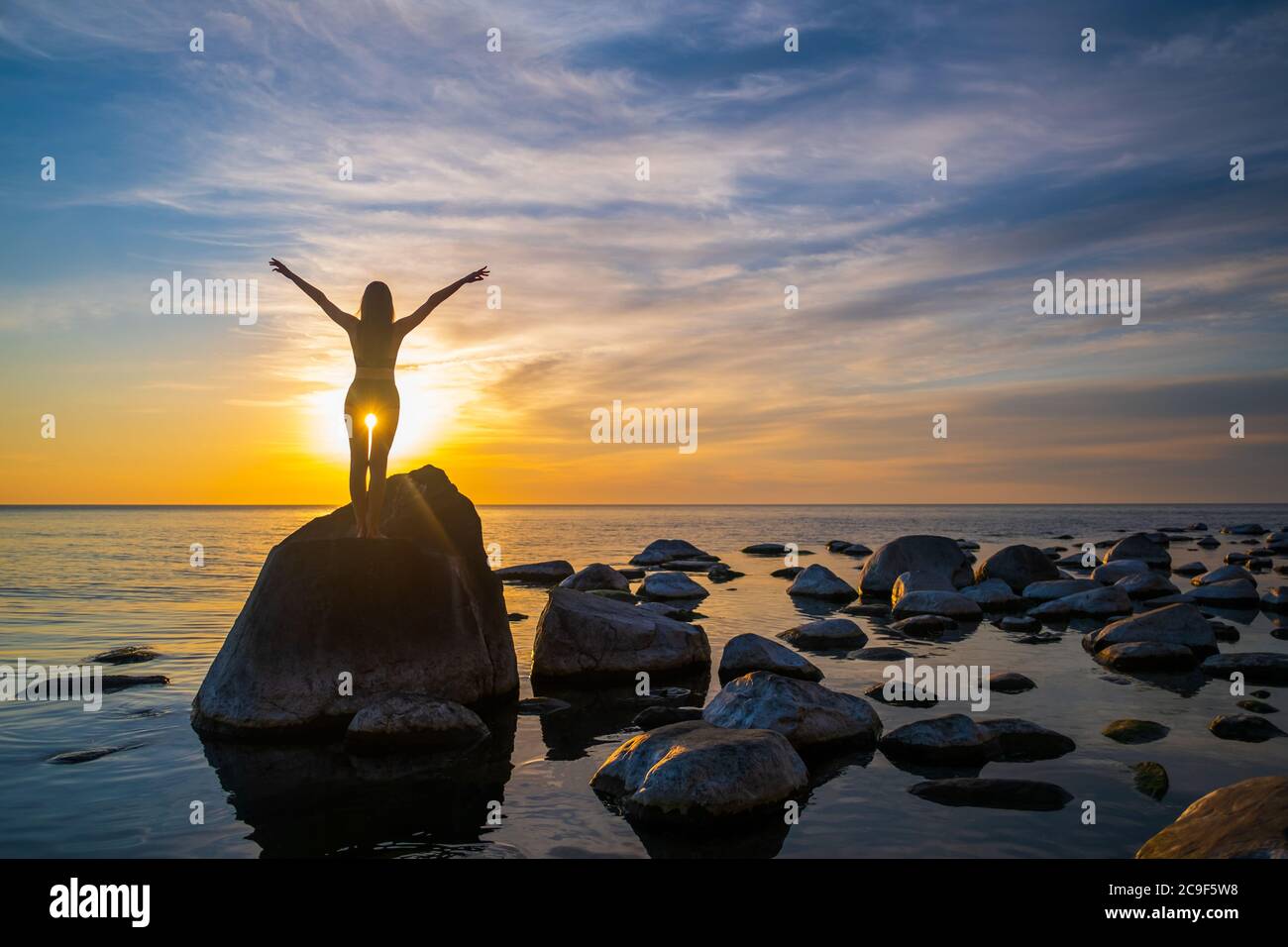Donna irriconoscibile che gode della libertà durante il tramonto Foto Stock