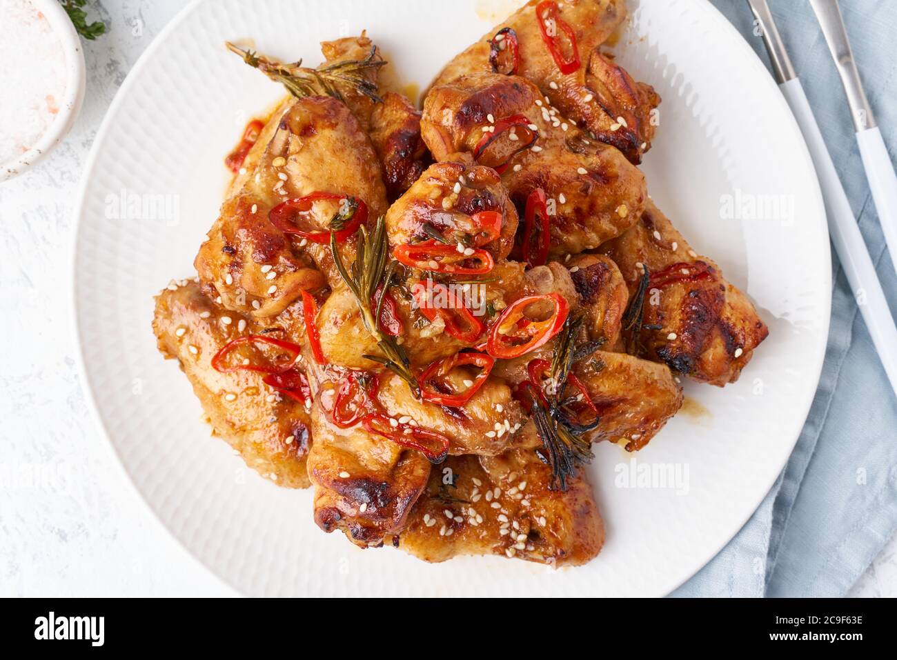 Ali di pollo alla griglia. Piano cottura lento dolce e piccante. Scalinata marinata al forno sul piatto Foto Stock