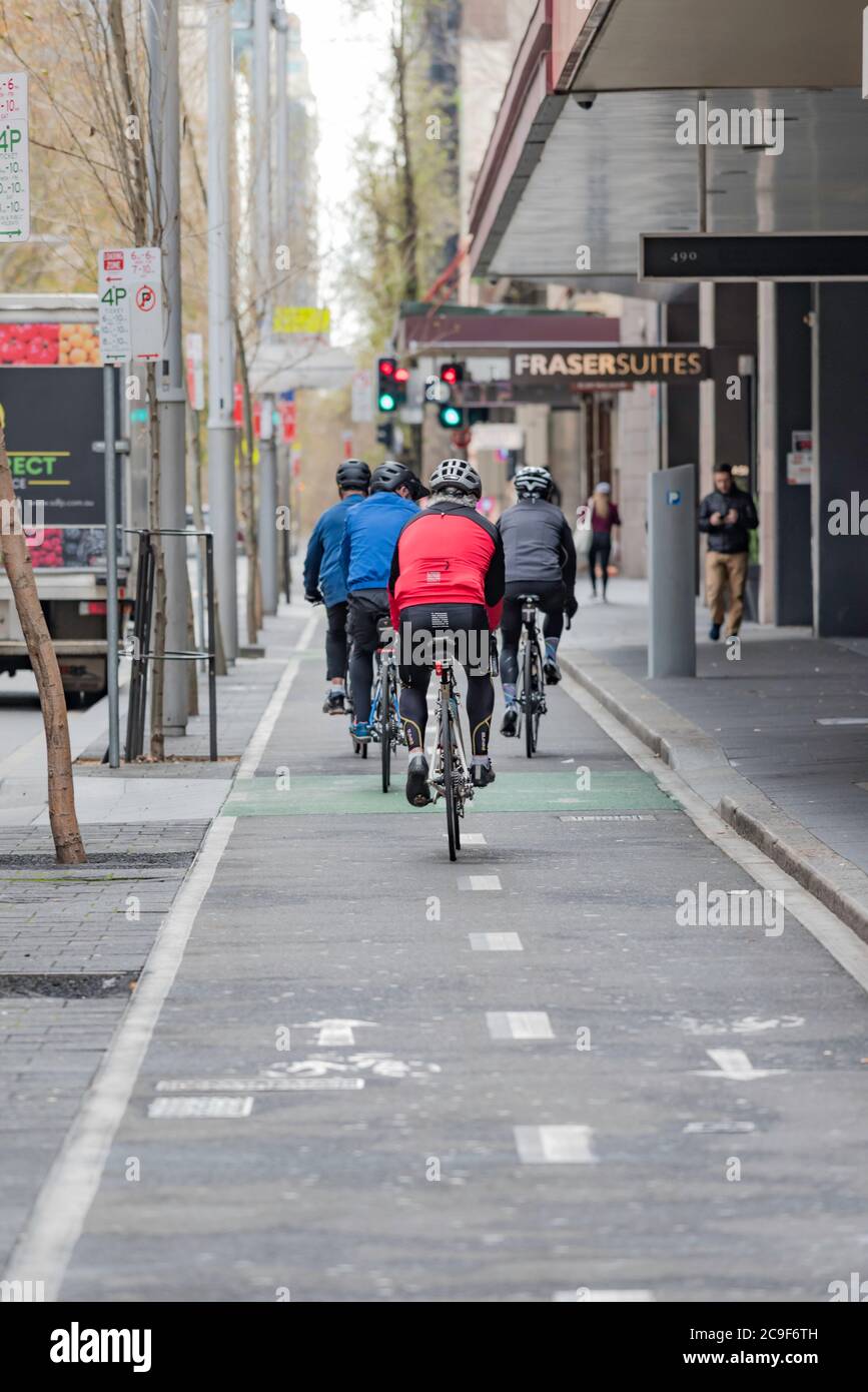 I ciclisti che cavalcano in una pista ciclabile dedicata durante il fine settimana mattina a Kent Street, Sydney, Australia Foto Stock