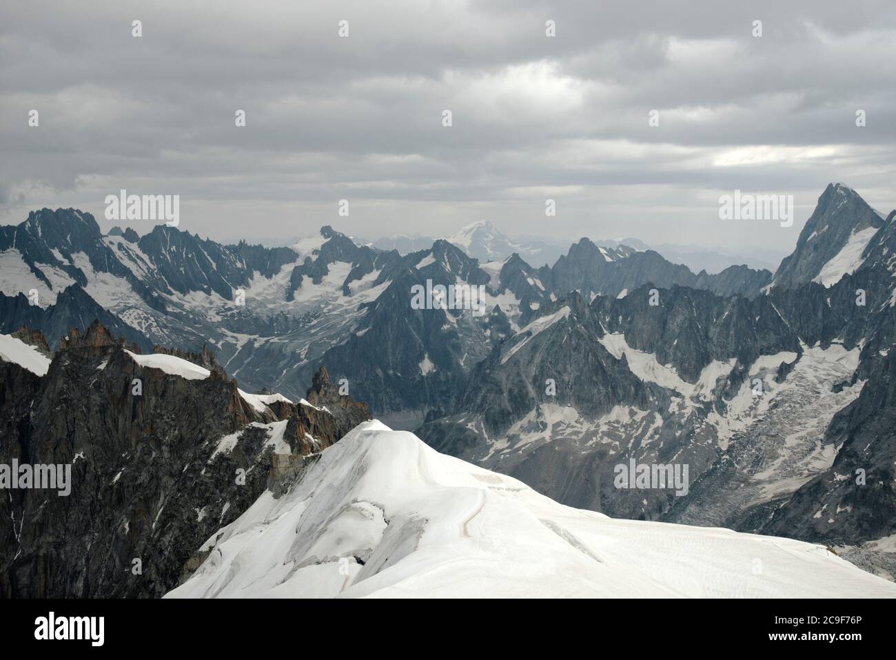 La neve copre le zone della roccia con nuvole grigio chiaro nel cielo. Foto Stock