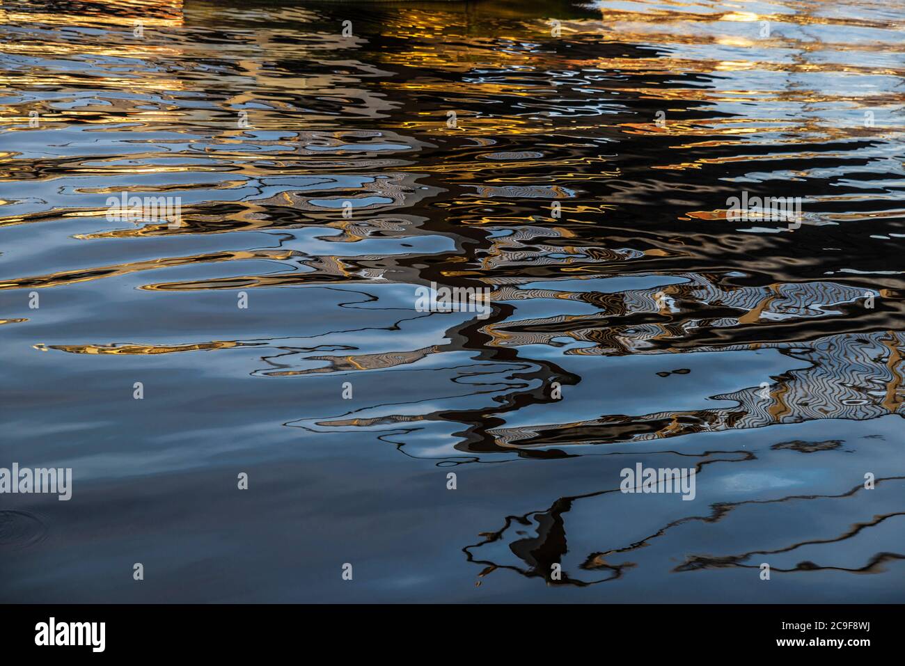 Luccica sull'acqua del fiume Liffey come sfondo astratto a Dublino, Irlanda Foto Stock