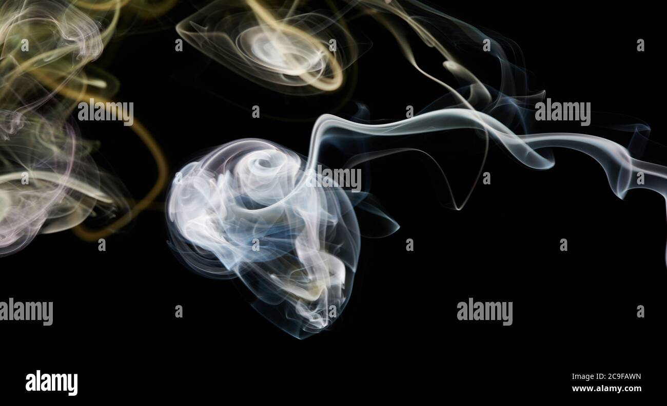 Vortice di fumo bianco e giallo su sfondo nero isolato Foto Stock