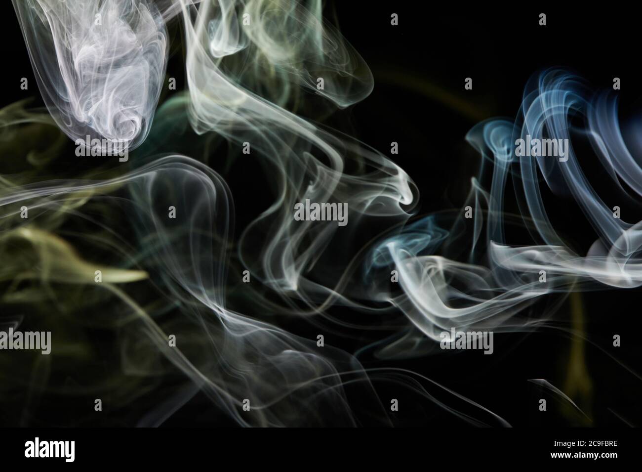 Flusso della curva di fumo gialla su sfondo nero isolato. Sfondo astratto Foto Stock