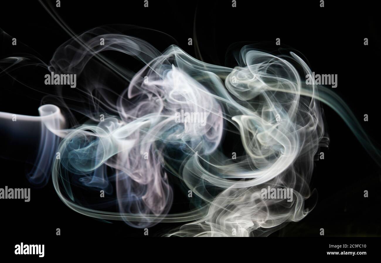 Fumo bianco forma ricci su sfondo nero isolato Foto Stock