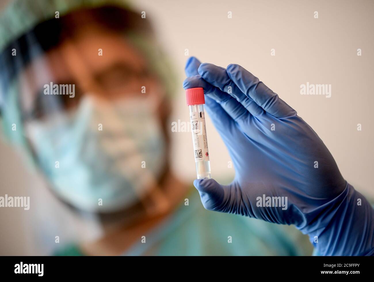 30 luglio 2020, Brandeburgo, Schönefeld: Un medico tiene uno striscio per  un test del coronavirus nel centro di test della corona all'aeroporto di  Schoenefeld. All'aeroporto di Schoenefeld di Berlino, i primi rimpatriati