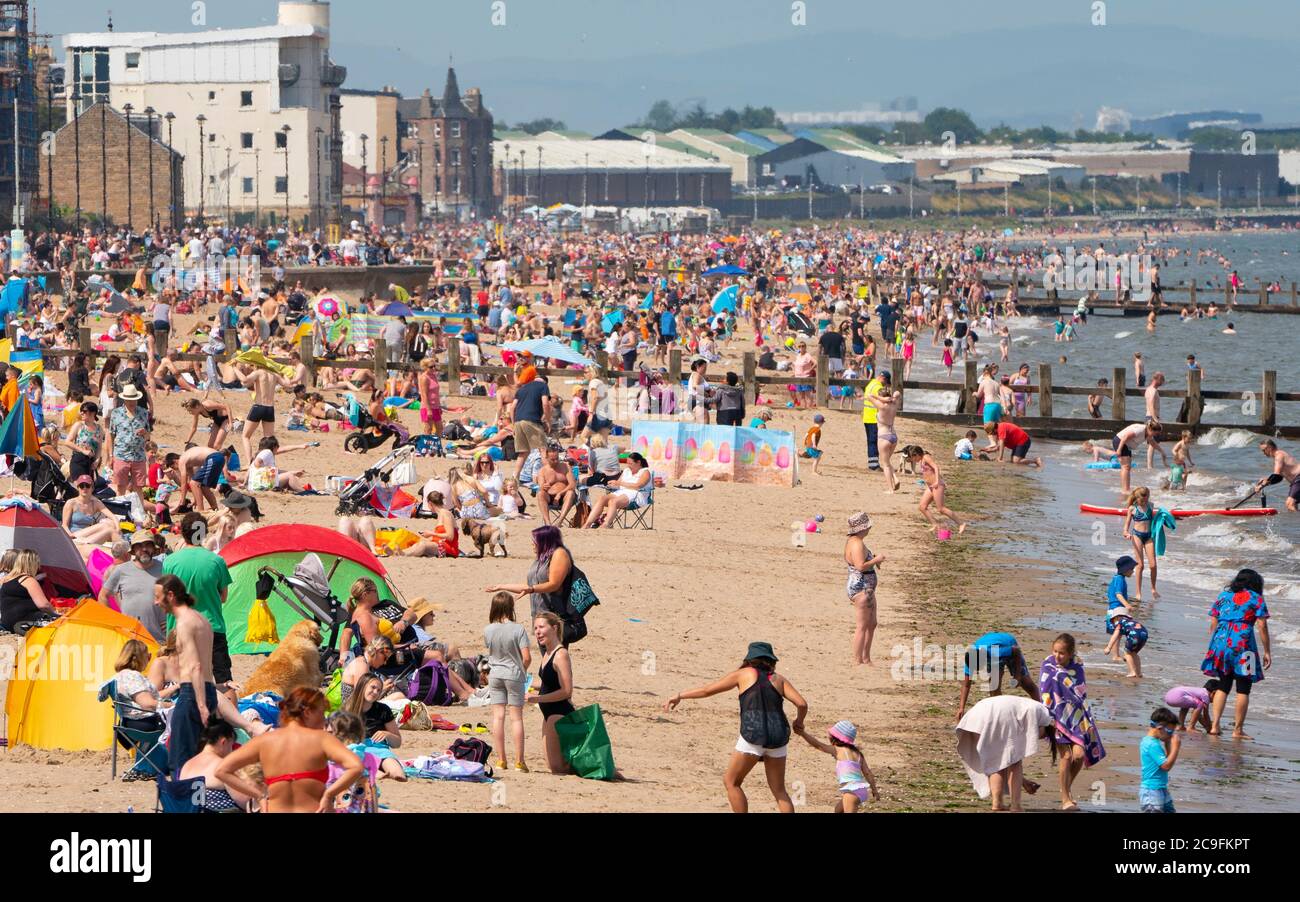 Edimburgo, Scozia, Regno Unito. 31 luglio 2020. La temperatura di 25°C e il sole hanno portato enormi folle a Portobello Beach fuori Edimburgo. Molti grandi gruppi di adolescenti stavano godendo la spiaggia e le bevande alcoliche erano molto popolari. Iain Masterton/Alamy Live News Foto Stock
