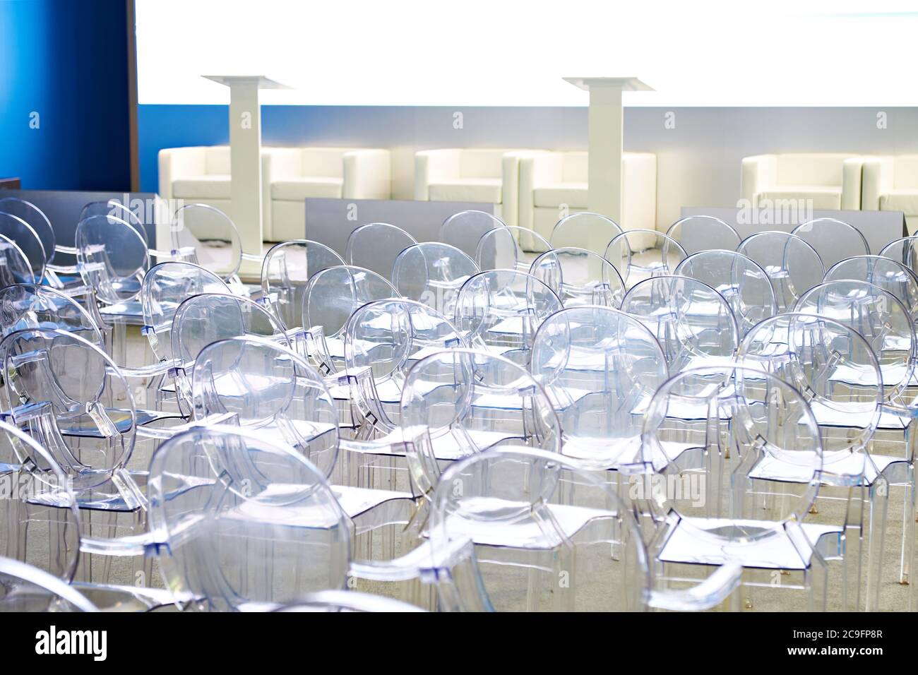 Sedie in plastica trasparente nella sala conferenze Foto Stock